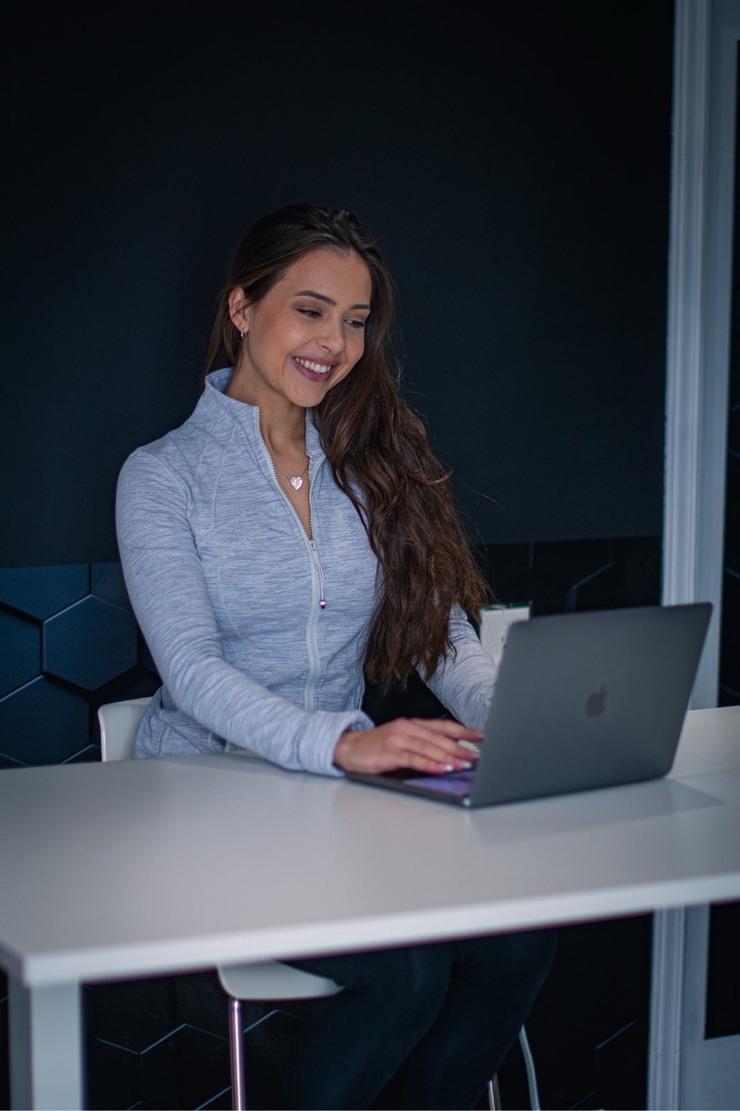 Meredith Parry smiling while working on her laptop.